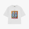 A white short-sleeve t-shirt by Palanca, featuring a colorful graphic print of flip-flops in a square box on the chest.